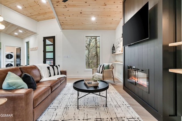 - Chinquapin Drive, Sevierville, TN 37862 - living room with light wood finished floors, a fireplace, wooden ceiling, stacked washer / dryer, and lofted ceiling