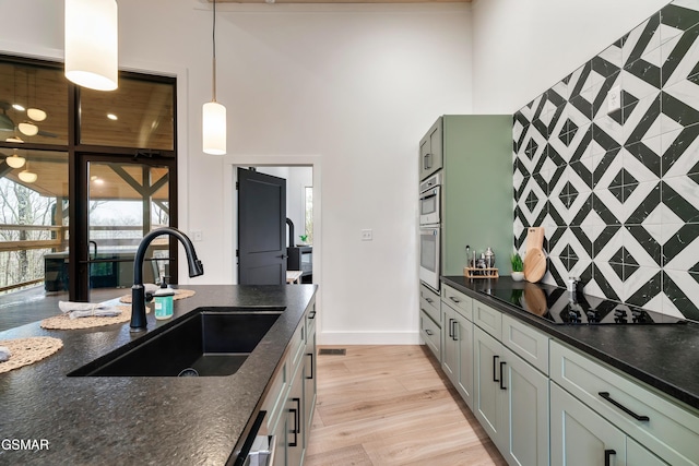 - Chinquapin Drive, Sevierville, TN 37862 - kitchen featuring a towering ceiling, black electric cooktop, a sink, baseboards, and light wood-style floors