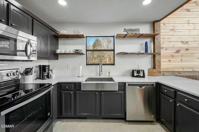 kitchen with open shelves, backsplash, appliances with stainless steel finishes, and a sink