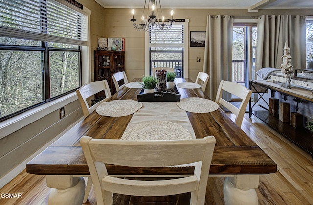 dining space with wood-type flooring and a notable chandelier