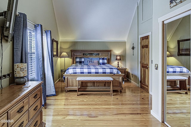 bedroom featuring light wood-style flooring, baseboards, and vaulted ceiling