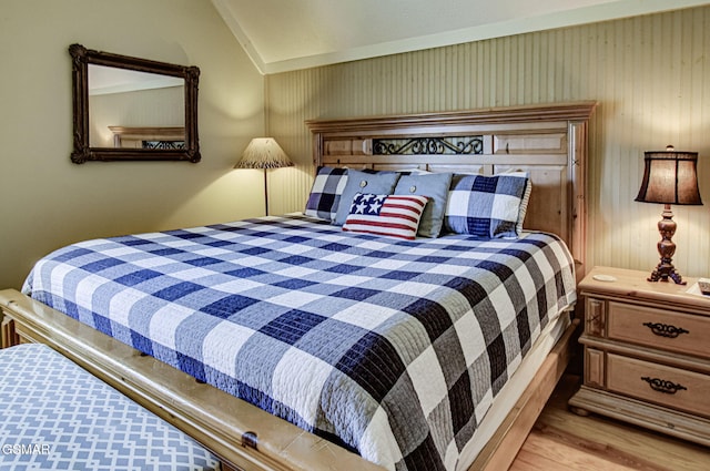 bedroom featuring lofted ceiling and wood finished floors