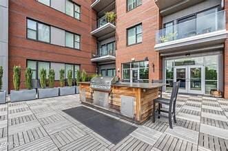 view of patio / terrace with an outdoor kitchen, area for grilling, and a bar