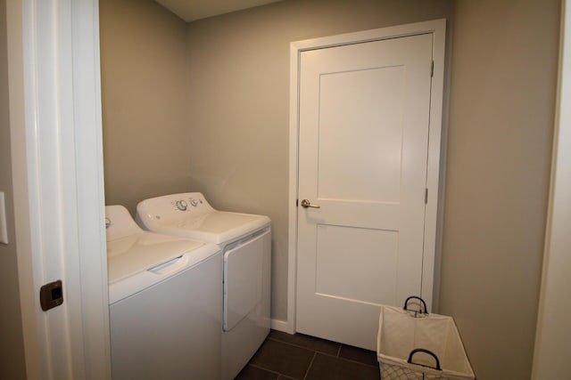 laundry area featuring washing machine and dryer and dark tile patterned floors