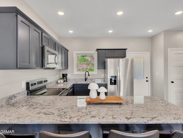 3141 Teaster Ln Unit 2, Pigeon Forge, TN 37863 - kitchen with stainless steel appliances, a peninsula, a kitchen bar, recessed lighting, and light stone counters