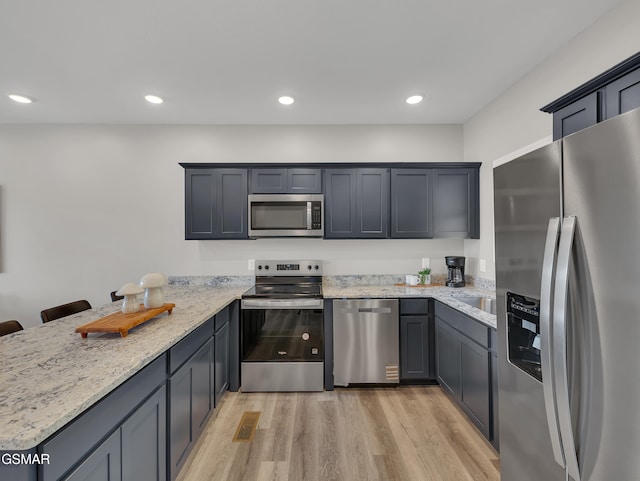 3141 Teaster Ln Unit 2, Pigeon Forge, TN 37863 - kitchen featuring appliances with stainless steel finishes, light wood-type flooring, light stone counters, a peninsula, and recessed lighting