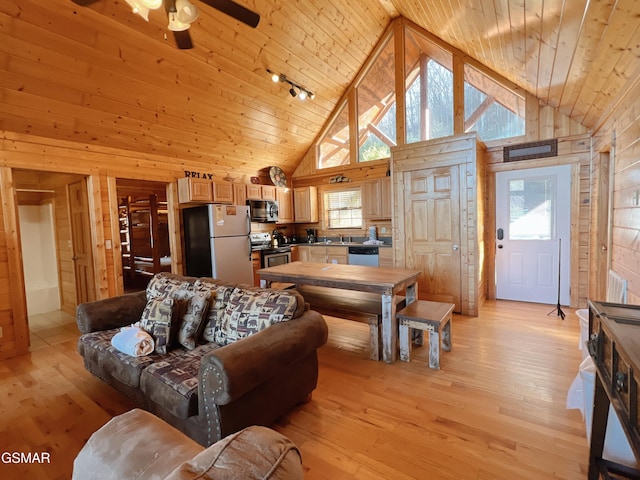 living room featuring a healthy amount of sunlight, wooden ceiling, wood walls, and light wood-type flooring