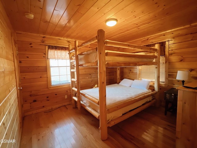 bedroom with wooden ceiling, hardwood / wood-style flooring, and wooden walls
