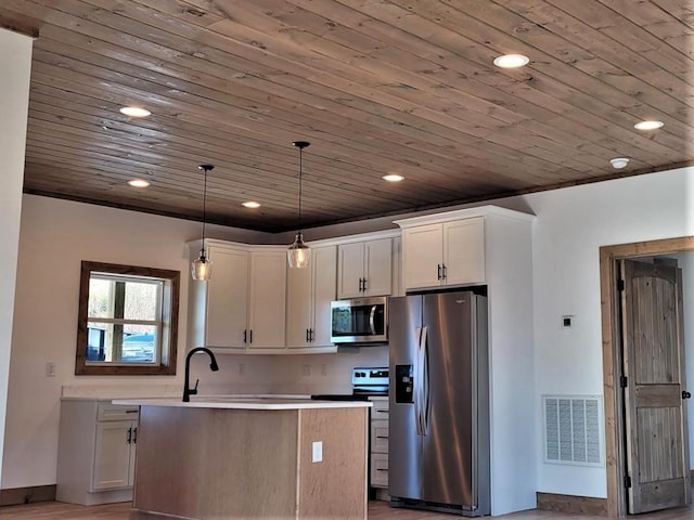 kitchen with decorative light fixtures, a center island, white cabinetry, and stainless steel appliances