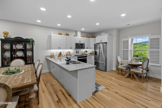 1032 Patriots Dr, Dandridge, TN 37725 - kitchen with appliances with stainless steel finishes, a peninsula, light stone countertops, white cabinets, and recessed lighting