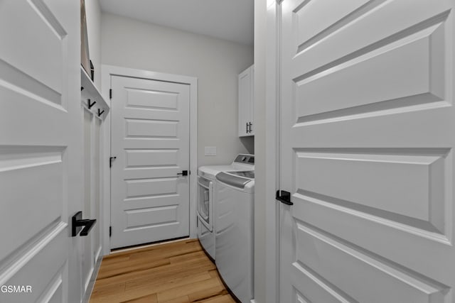 1032 Patriots Dr, Dandridge, TN 37725 - washroom featuring washing machine and dryer, cabinet space, and light wood-style flooring