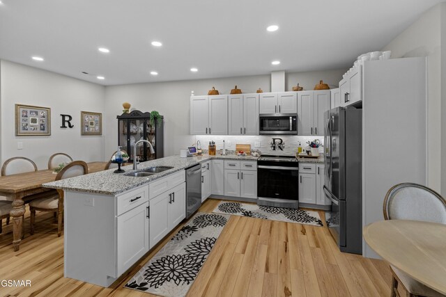 1032 Patriots Dr, Dandridge, TN 37725 - kitchen with appliances with stainless steel finishes, a peninsula, light wood finished floors, tasteful backsplash, and recessed lighting