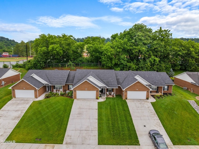 1032 Patriots Dr, Dandridge, TN 37725 - view of front of property with brick siding, a front yard, concrete driveway, and an attached garage