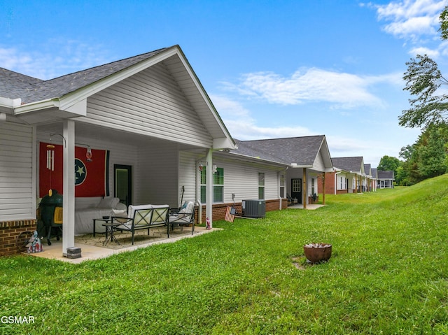 1032 Patriots Dr, Dandridge, TN 37725 - rear view of house featuring a patio, a lawn, an outdoor hangout area, a shingled roof, and brick siding