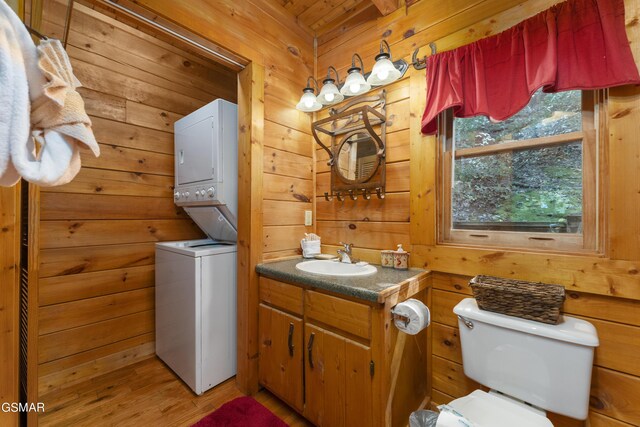 1814 Rhododendron Ln, Sevierville, TN 37876 - bathroom featuring vanity, stacked washing maching and dryer, toilet, and wooden walls