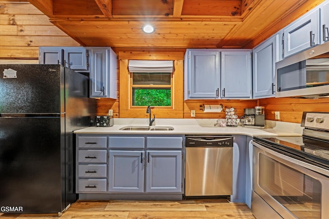 308 Brown Wren Way, Gatlinburg, TN 37738 - kitchen with stainless steel appliances, wooden ceiling, gray cabinets, wooden walls, and light countertops