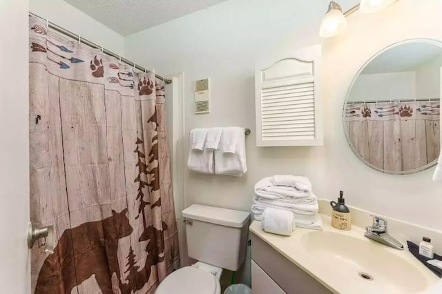 bathroom featuring vanity, curtained shower, toilet, and a textured ceiling