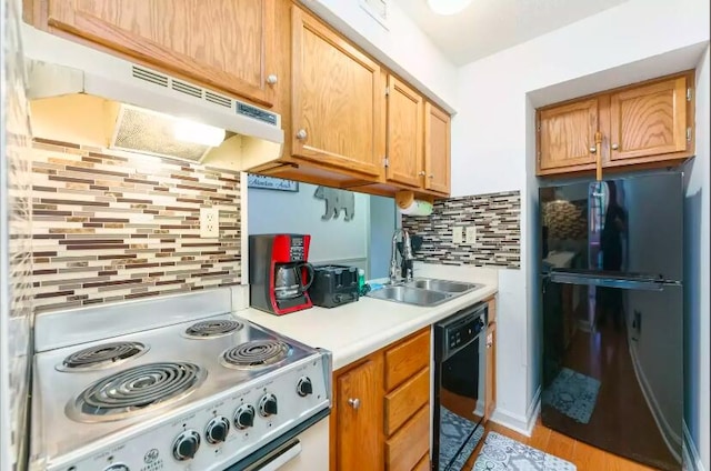 kitchen with black appliances, backsplash, and sink