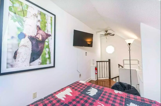 bedroom featuring ceiling fan, a textured ceiling, and vaulted ceiling