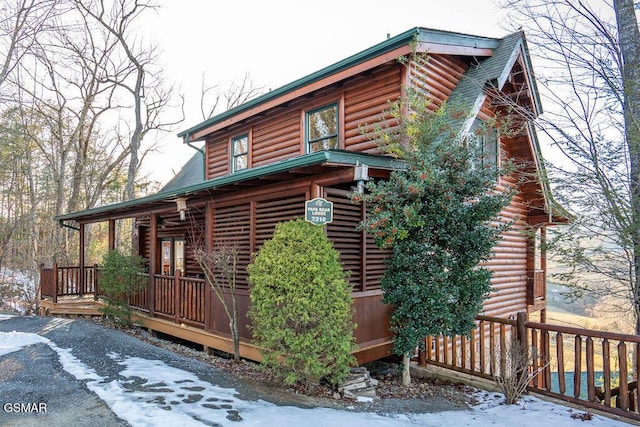 log-style house featuring covered porch