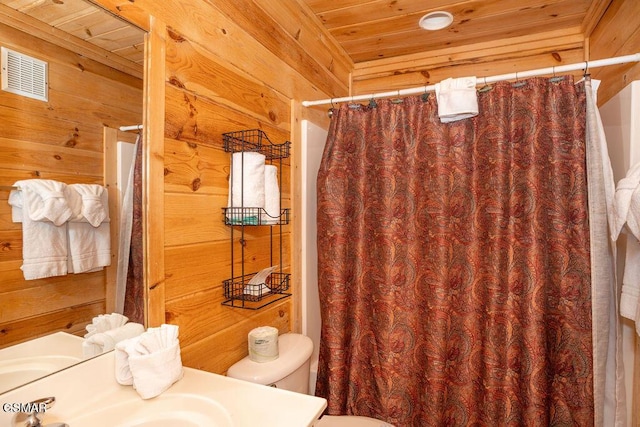 bathroom with toilet, sink, wooden ceiling, and wood walls