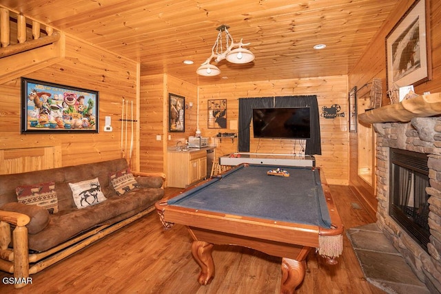 rec room with a stone fireplace, billiards, wood walls, wood ceiling, and dark wood-type flooring