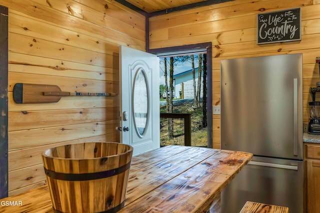 doorway to outside featuring wood ceiling and wood walls