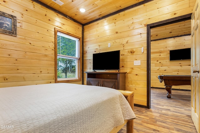 bedroom featuring light hardwood / wood-style floors, wooden walls, wooden ceiling, and billiards