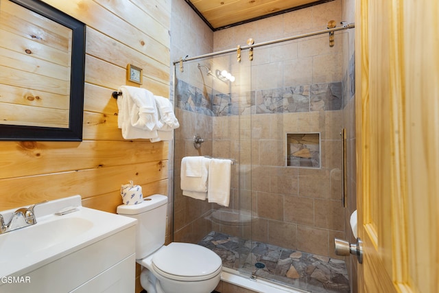 bathroom featuring wood walls, vanity, a shower with shower door, and toilet