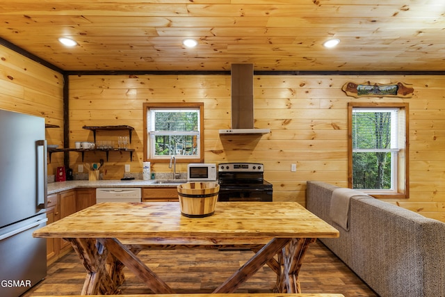 kitchen featuring wood walls, white appliances, and sink