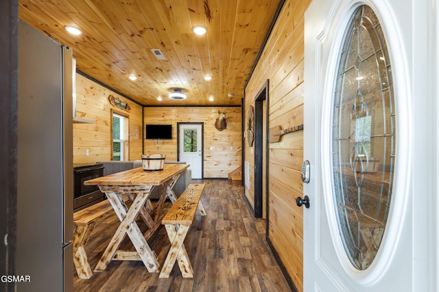 dining room featuring wooden walls, wooden ceiling, and dark hardwood / wood-style floors