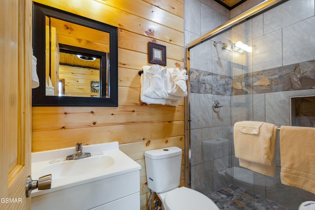 bathroom featuring vanity, toilet, a shower with door, and wooden walls