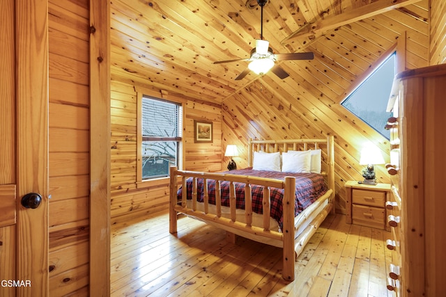 bedroom with wood ceiling, vaulted ceiling, ceiling fan, wooden walls, and light hardwood / wood-style floors