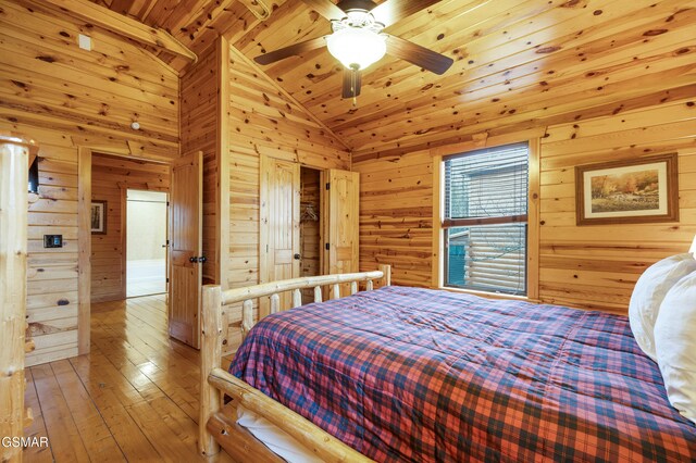 bedroom featuring ceiling fan, high vaulted ceiling, wood-type flooring, wooden walls, and wood ceiling