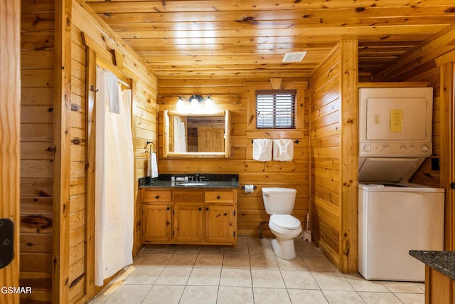 bathroom with vanity, tile patterned flooring, toilet, wood ceiling, and stacked washer / dryer