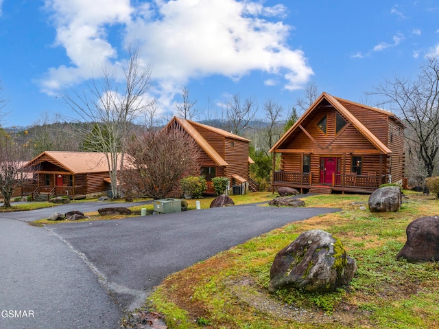 log-style house featuring a wooden deck