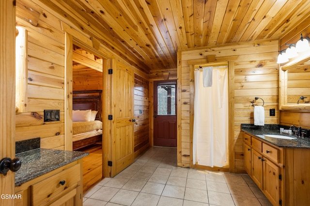 bathroom featuring tile patterned floors, wood walls, vanity, and wooden ceiling