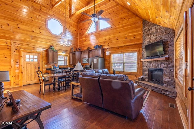 living area featuring dark wood-style floors, a fireplace, visible vents, wood ceiling, and wood walls