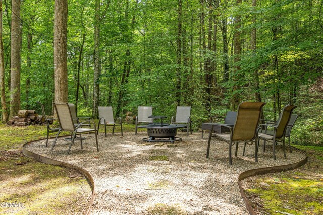 2313 Bogle Spring Loop, Sevierville, TN 37862 - view of patio / terrace featuring an outdoor fire pit and a forest view