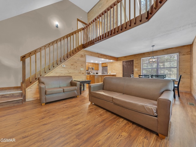 2733 Timber Way, Pigeon Forge, TN 37863 - living area with light wood finished floors, wood walls, stairway, a towering ceiling, and a chandelier