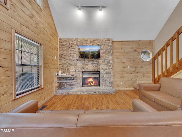 2733 Timber Way, Pigeon Forge, TN 37863 - living room featuring wood walls, wood finished floors, a stone fireplace, and plenty of natural light
