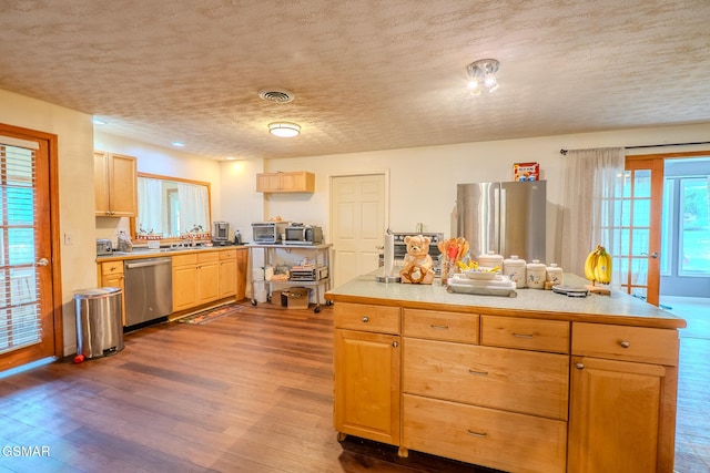 kitchen featuring dark wood-type flooring, a textured ceiling, visible vents, and stainless steel appliances
