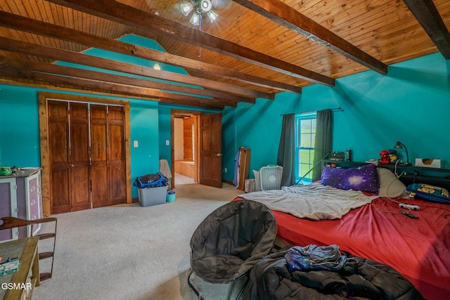 carpeted bedroom featuring beamed ceiling, wooden ceiling, and a closet