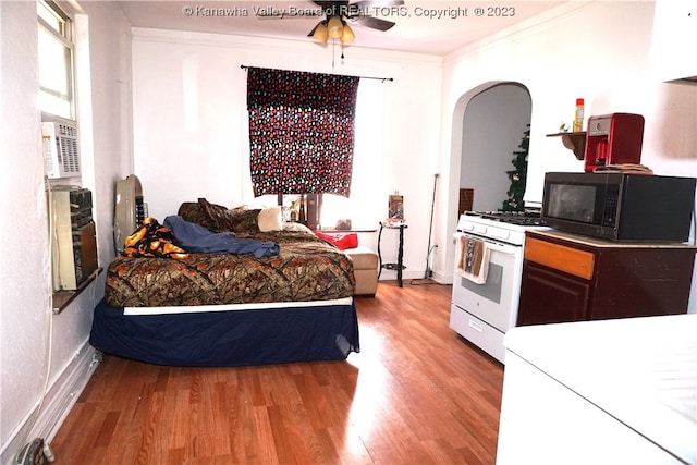 bedroom with light hardwood / wood-style flooring, ceiling fan, and ornamental molding