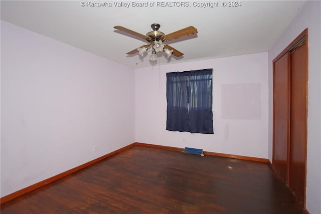 spare room with dark wood-type flooring and ceiling fan