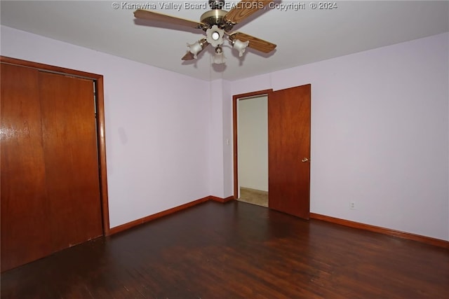 spare room with dark wood-type flooring and ceiling fan