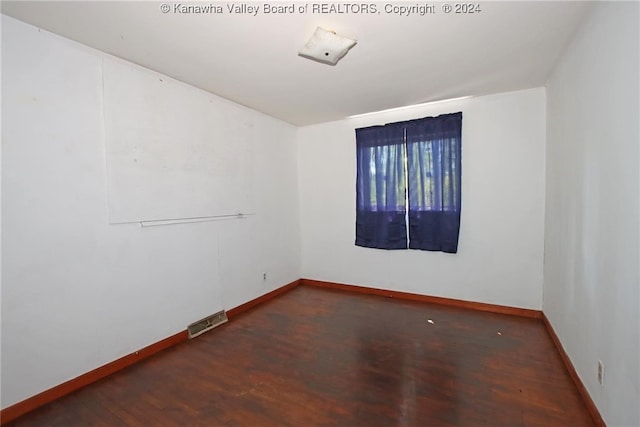 unfurnished room featuring dark wood-type flooring