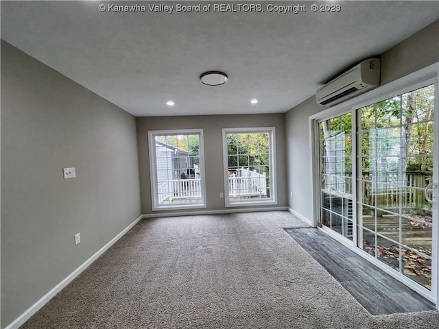 unfurnished room featuring dark colored carpet and an AC wall unit