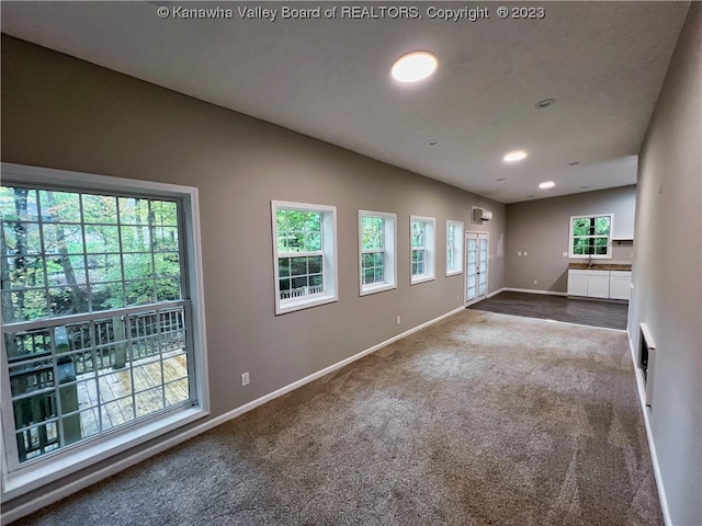 unfurnished room with dark colored carpet