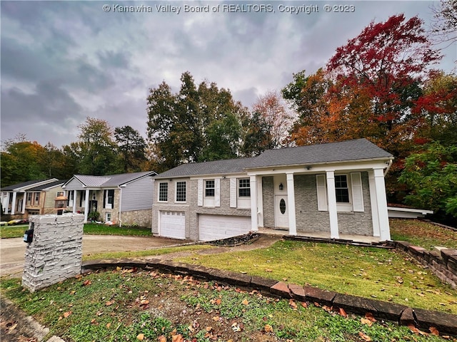 view of front facade with a front yard, covered porch, and a garage